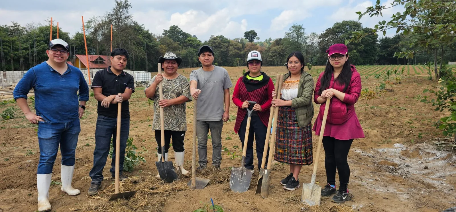 Integrantes y voluntarios de AKIC reunidos en el área de cultivo